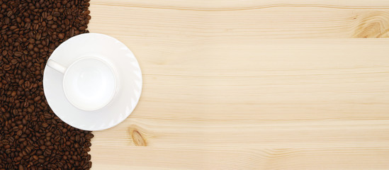 top view of empty white coffee cup with saucer and roasted coffee beans on wooden background with copy space