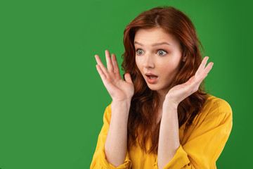 Surprised Girl Looking Aside Posing On Green Background In Studio