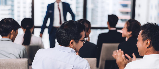 Businessman standing in front of group of people in consulting meeting conference seminar at hall...