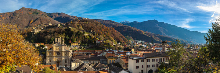 Stunning aerial panorama view of Bellinzona old town with church Chiesa Collegiata dei SS Pietro e Stefano, Montebello castle and Swiss Alps in background, on sunny autumn day, Ticino, Switzerland