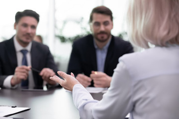 Back view of female job candidate talk make first impression at interview with recruiters, woman...