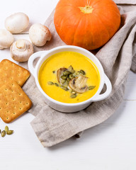 Tasty Homemade Pumpkin Soup with Mushrooms om White Wooden Background Vertical