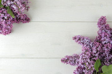 Spring flowers. Frame of twigs of blooming lilac on a white wooden table. top view. place for text