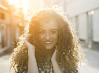 Fototapeta premium Atmospheric portrait of smiling young natural beautiful lady 
