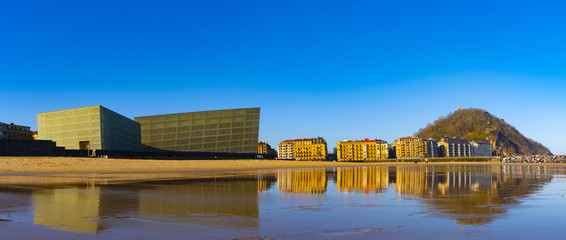 Fototapeta premium buildings are reflected in the water of the beach, Zurriola, Ciudad de Donostia, Euskadi