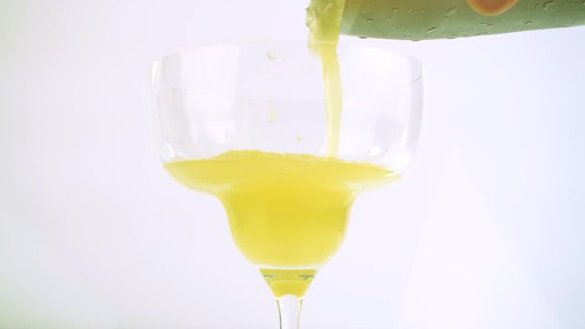 Pouring Orange Margarita in a Cocktail Glass on white Background