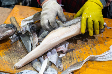 Person Cleaning, Chopping and Peeling off Fish Skin on Seafood Market.