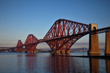Fototapeta na wymiar puente rojo de construcción moderna sobre un río en el que se ve reflejado