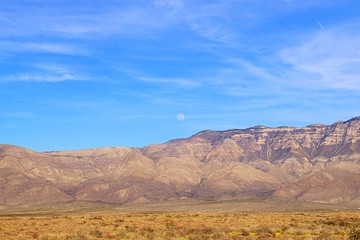 View of full moon rising over mountains during the evening