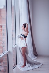 young woman in black underwear enjoying the morning near a big panoramic window