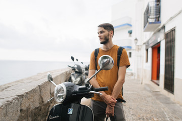 Naklejka premium young man with a moped on a street of Spain