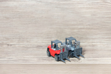 Toy forklift on wood background.
