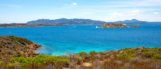 Fototapeta premium Caprera Island and Spiaggia di Cala Portese harbor at the Tyrrhenian Sea coastline with Isola Porco island, La Maddalena archipelago and the Sardinian mainland in background in Sardinia, Italy
