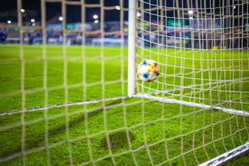 The ball flies to the soccer gate on green grassy field