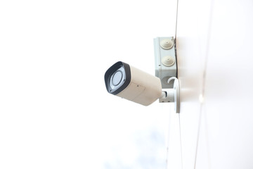 A security camera hangs on the wall of the building