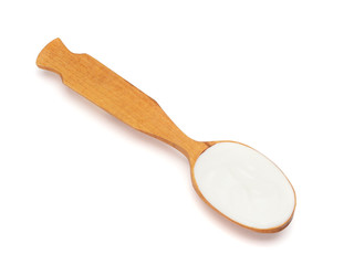 Liquid yogurt in a wooden spoon on white background
