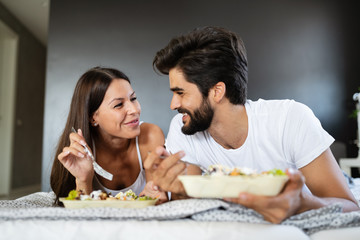 Romantic happy couple having breakfast in bed