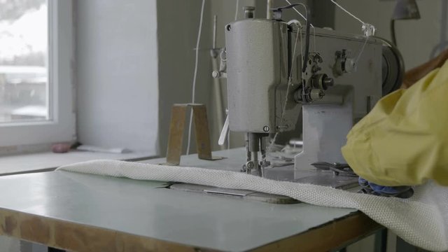 Work behind a sewing machine in a textile factory of non-horny fabric