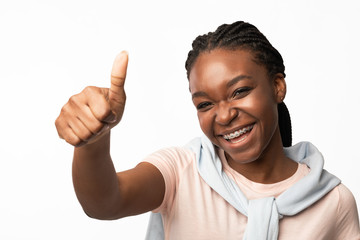 Smiling African American Girl Gesturing Thumbs-Up Over White Background