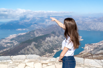 Traveler girl points finger hand to landscape. Vacation trip concept. Montenegro