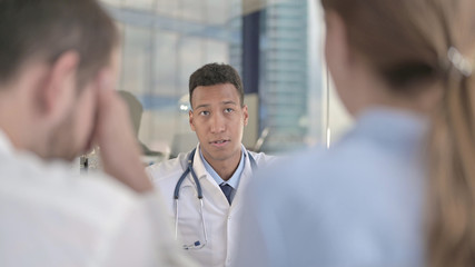 The Upset Couple having Conversation with African Young Doctor