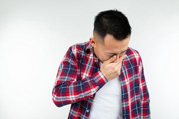 handsome asian guy in a checkered shirt wide open close mouth on a white studio background with copy space