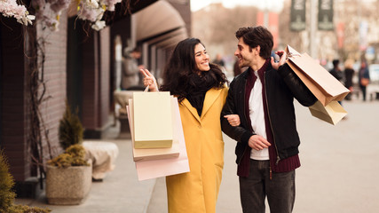Woman showing something in shop window to her husband