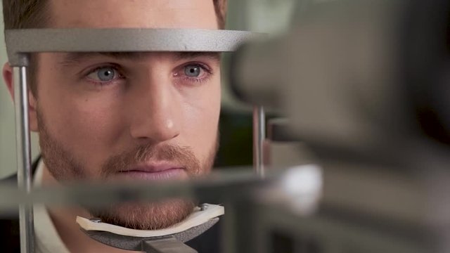 Closeup portrait of young man on vision diagnosis