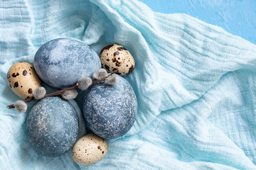 Blue Easter eggs on blue background. Naturally Eggs painted with hibiscus with marble stone effect. Eco paint. Happy Easter card