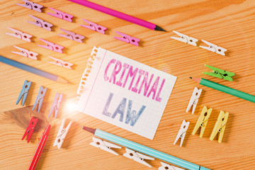 Writing note showing Criminal Law. Business concept for legal system which relates to punishing those commits crime Colored clothespin papers empty reminder wooden floor background office