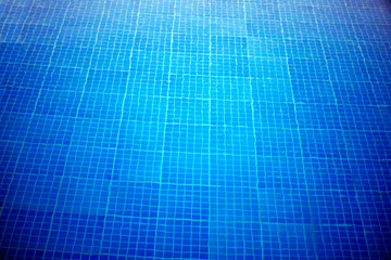 Blue tiles on the bottom of the pool with water. Beautiful cool water in swimming pool mosaic bottom. Texture bottom of the pool.