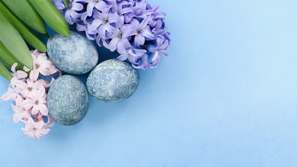 Easter background with blue eggs and spring flowers. Top view with copy space. Happy Easter Spring Festive greeting card. Holidays Naturally Eggs painted with hibiscus with marble stone effect