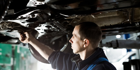 Obraz na płótnie Canvas Car mechanic working at automotive service center