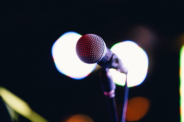 Concert microphone on a stand in front of the light
