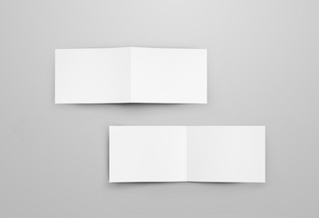 Mockup of two horizontal open bifolds with realistic shadows. White blank brochure for design presentation.