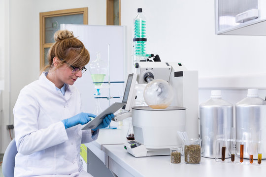 Chemist in laboratory controls chemical process with tablet