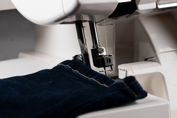 Jeans sewing using professional sewing machine, there are some dust on thread mechanism