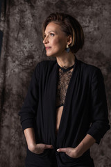 vertical closeup portrait of a young woman in profile on a textured gray background