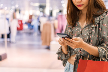 Young asian woman with shopping bags using smart phone and shopping at mall, Woman lifestyle concept