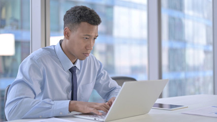 The African Businessman working on Laptop in Office