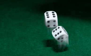 Playing casino games dice throw on a green table.