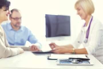 Fototapeta premium Attentive senior doctor listenint to patient in her office