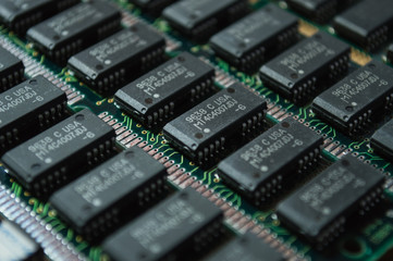 Green electric circuit board with microchips, close up.