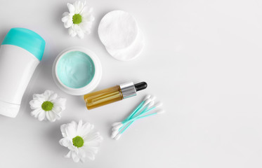 Layout with cream with oil and deodorant on white background