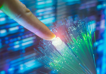 finger touching fiber optic on technology background