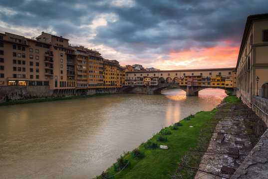 Panoramic sunset view of famous Ponte Vecchio over Arno River in Florence, Italy.