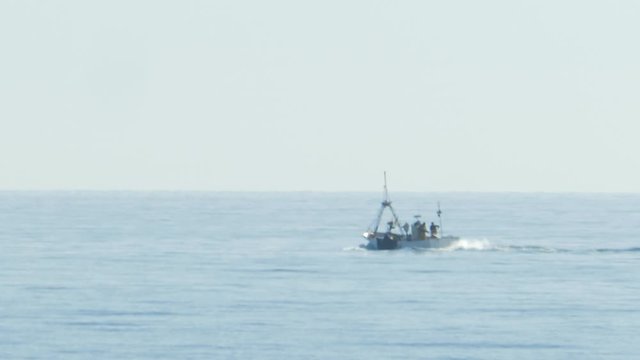 Isolated Small Fishing Boat Sailing in Open Sea SLOMO
