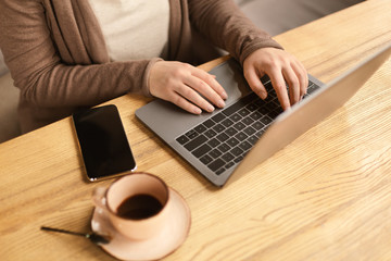Female working on laptop and drinking coffee