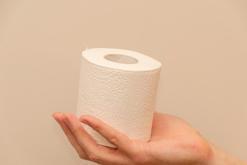 Man's hand holding and giving toilet paper roll
