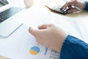 Businessman is inspecting and checking the business reports graphs to audit the financial reports....